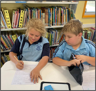 An imge of two, happy students working togther.